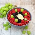 Overnight-Oats-mit-Beeren Overnight-Oats mit Beeren und Mandelmus auf einem Löffel