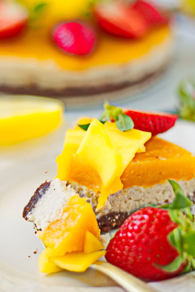 Veganer No Bake Mango-Kokos-Kuchen Kuchenstück auf Teller