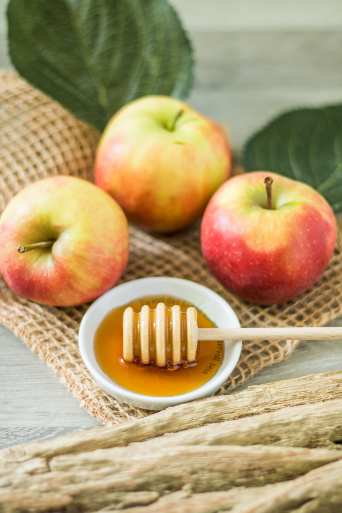 Apfelsüße . Süßen mit Apfeldicksaft, Äpfel mit Blättern und Apfelsüße mit Honiglöffel