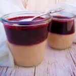 Veganes_Panna-Cotta Veganes Panna Cotta mit Blaubeersoße und Dessertlöffel in zwei Gläsern