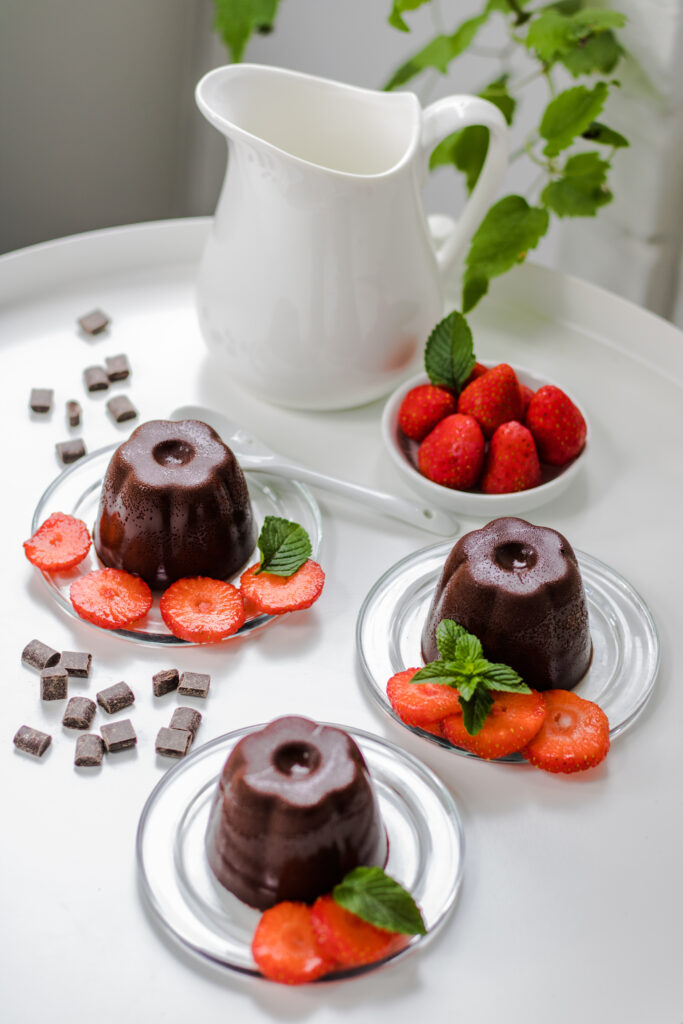 Vegane Schoko-Panna cotta mit Erdbeeren von oben mit Milchkännchen