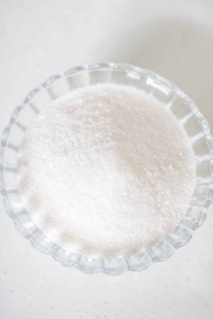 Arten von Kohlenhydraten: Einfachzucker: Raffinierter Zucker in einer Glasschale. Industriezuckerfrei leben