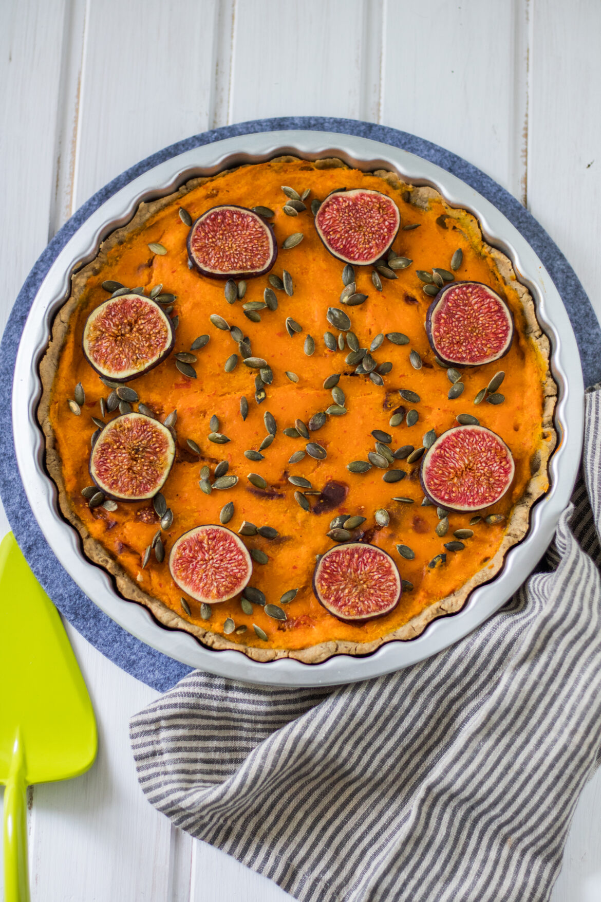 Glutenfreie und vegane Kürbis-Tarte Glutenfreie und vegane Kürbis-Tarte in Tarteform auf weißem Holzbrett von oben
