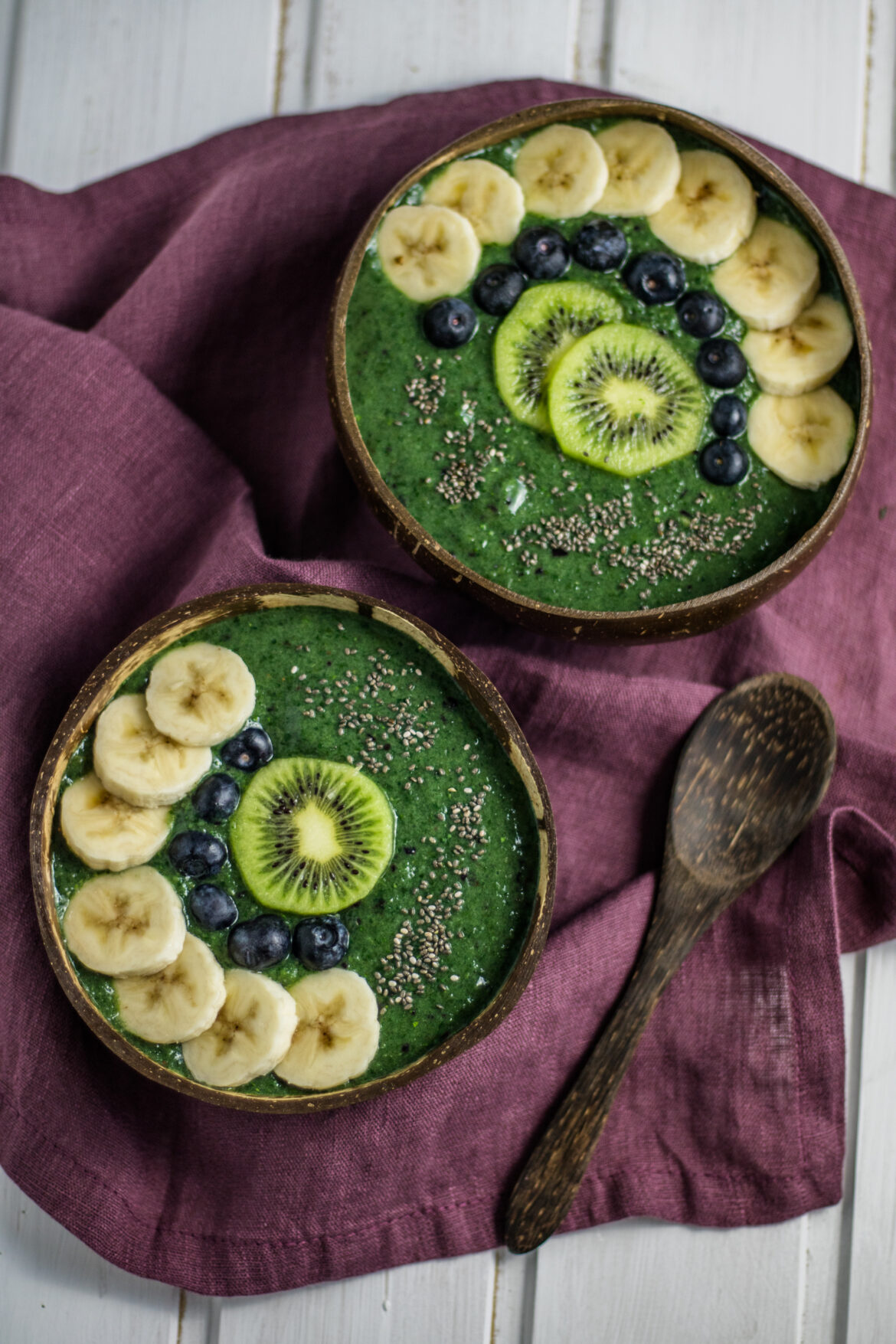 Smoothiebowl mit Spirulina und Chlorella von oben in Kokosnussschalen