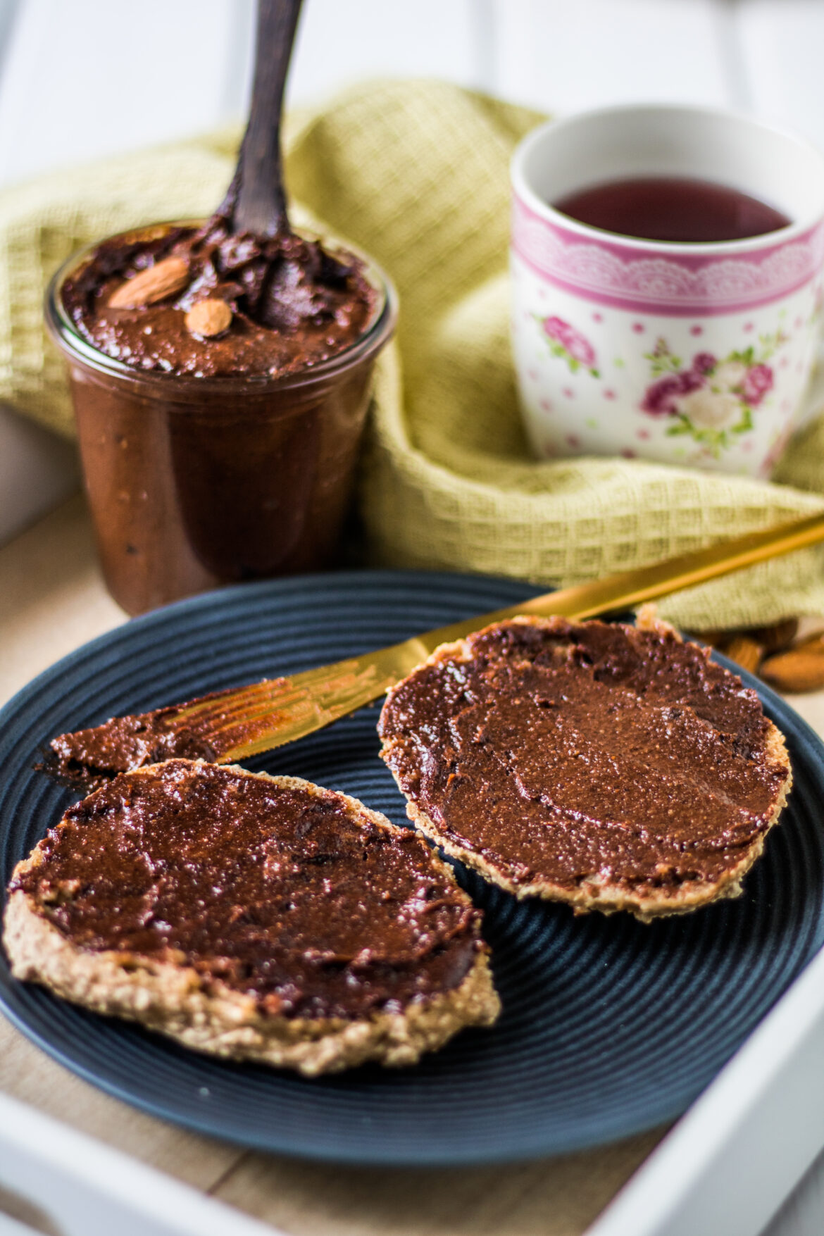 Vegane Nuss-Nougat-Creme selber machen. Veganes Nutella auf einem Brötchen mit Messer