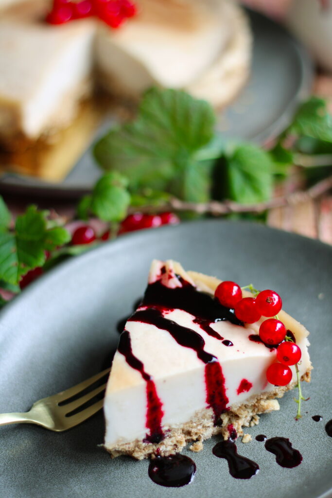 Veganer Käsekuchen ohne Soja - Stück mit Beerensoße